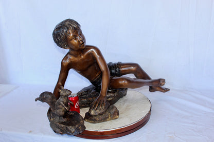 Adventurous boy with squirrel bronze statue -  Size: 36"L x 18"W x 22"H.
