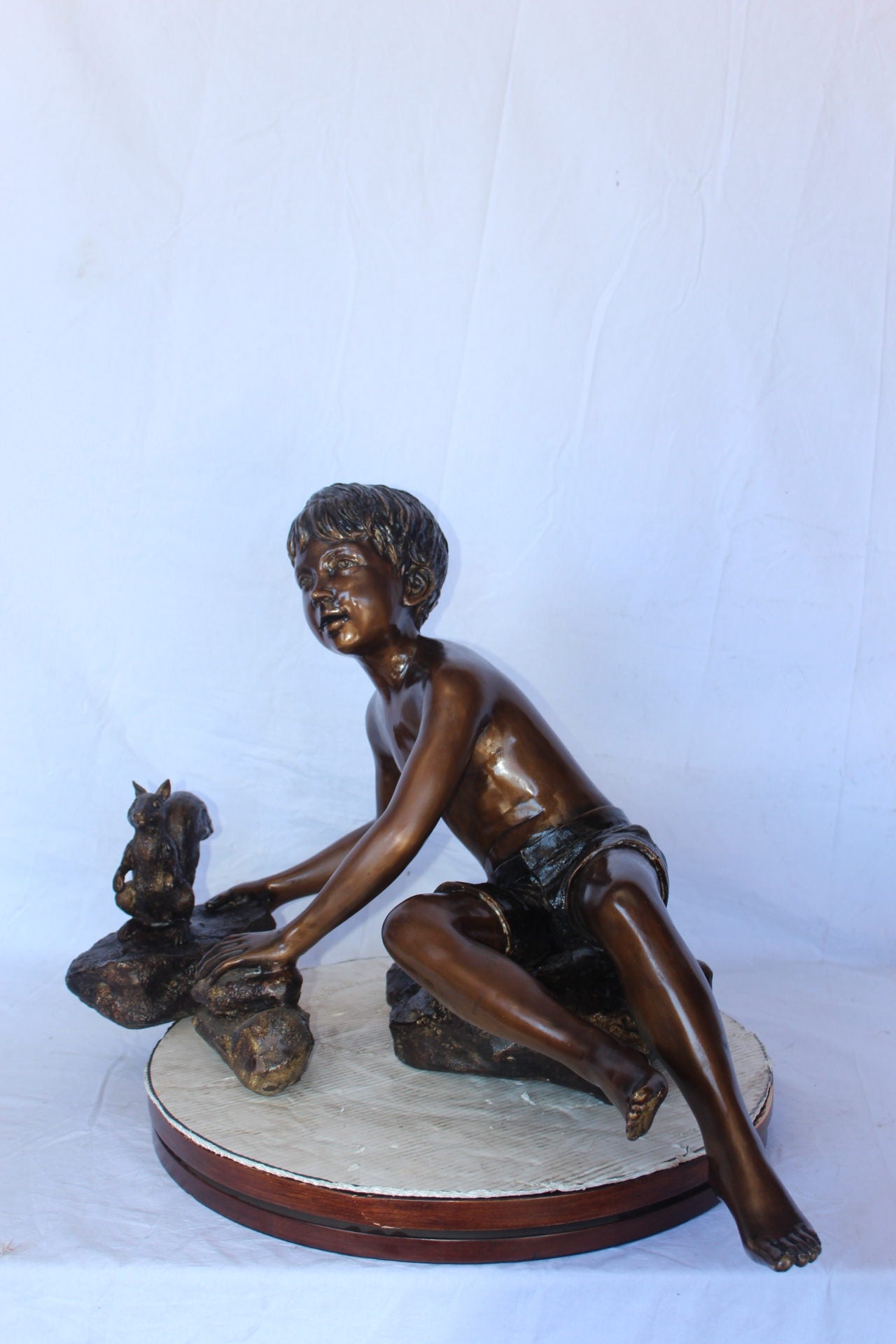 Adventurous boy with squirrel bronze statue -  Size: 36"L x 18"W x 22"H.