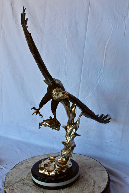 Soaring eagle carrying prey bronze statue -  Size: 16"L x 23"W x 39"H.