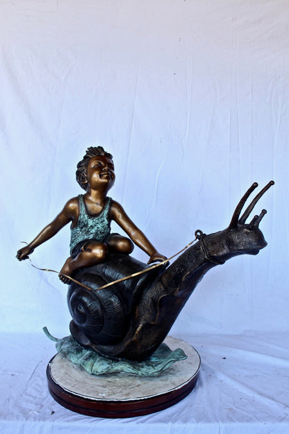 Happy boy riding a snail bronze statue fountain -  Size: 42"L x 14"W x 34"H.