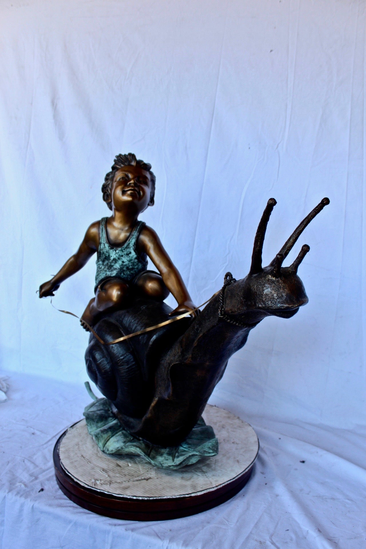 Happy boy riding a snail bronze statue fountain -  Size: 42"L x 14"W x 34"H.