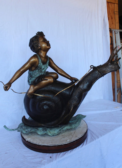 Happy boy riding a snail bronze statue fountain -  Size: 42"L x 14"W x 34"H.