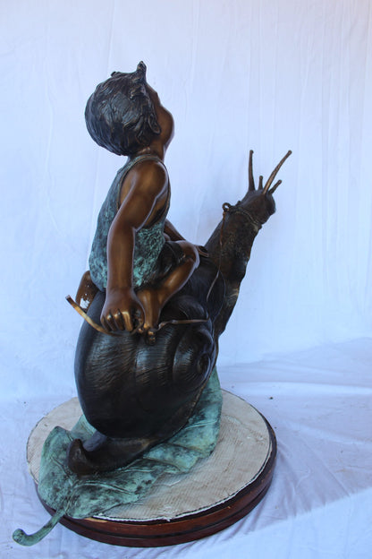 Happy boy riding a snail bronze statue fountain -  Size: 42"L x 14"W x 34"H.