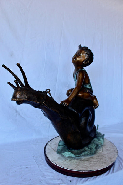 Happy boy riding a snail bronze statue fountain -  Size: 42"L x 14"W x 34"H.