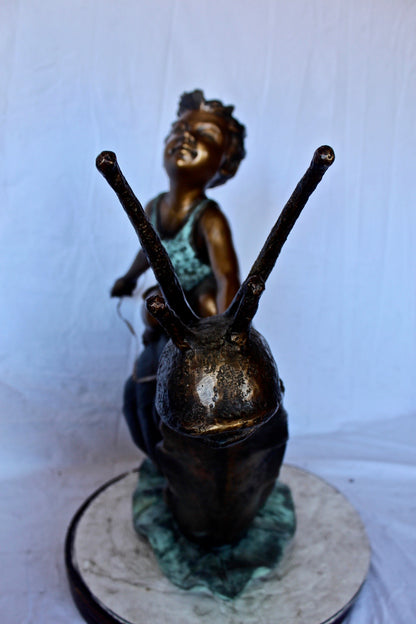 Happy boy riding a snail bronze statue fountain -  Size: 42"L x 14"W x 34"H.