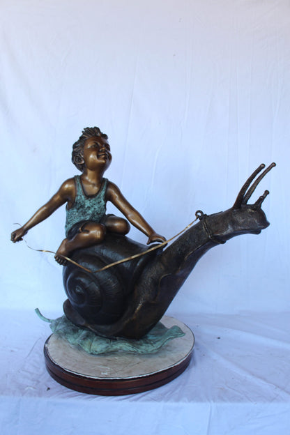 Happy boy riding a snail bronze statue fountain -  Size: 42"L x 14"W x 34"H.