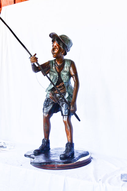 A young boy and his fishing journey bronze statue -  Size: 24"L x 26"W x 47"H.