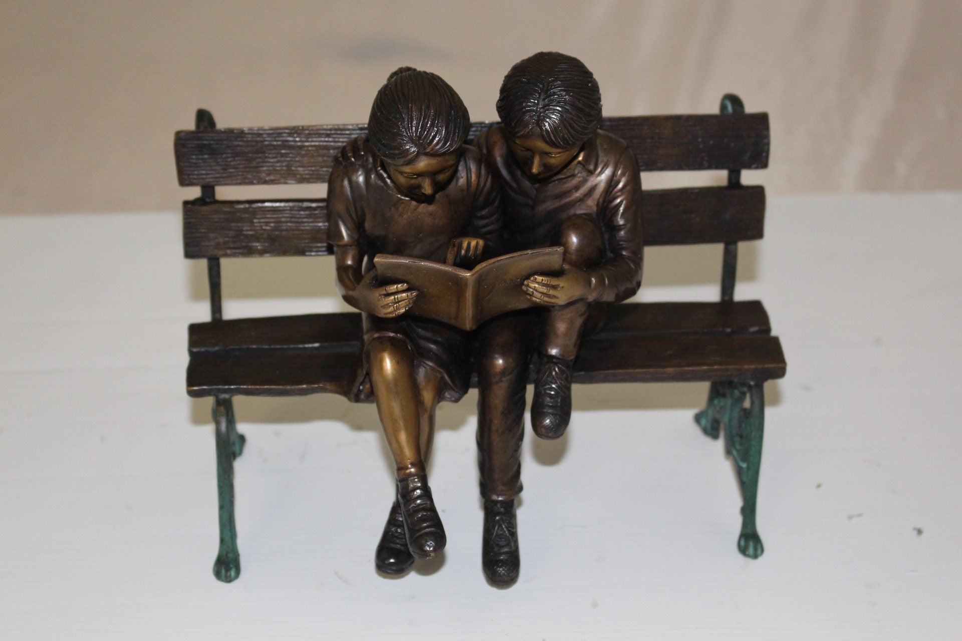 Two kids on bench reading a book - Bronze Statue -  Size: 9"L x 6"W x 8"H. 