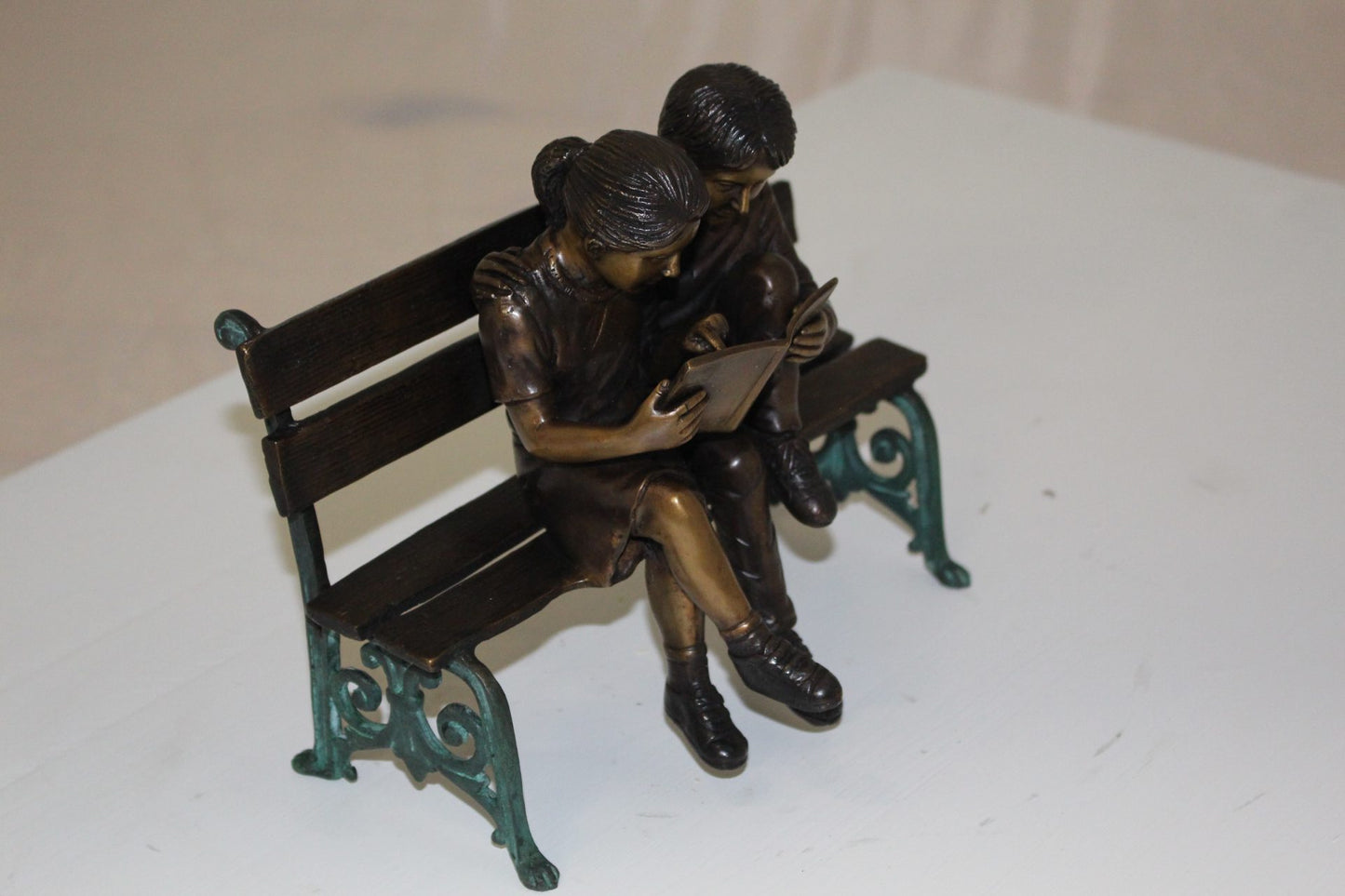Two kids on bench reading a book - Bronze Statue -  Size: 9"L x 6"W x 8"H. 