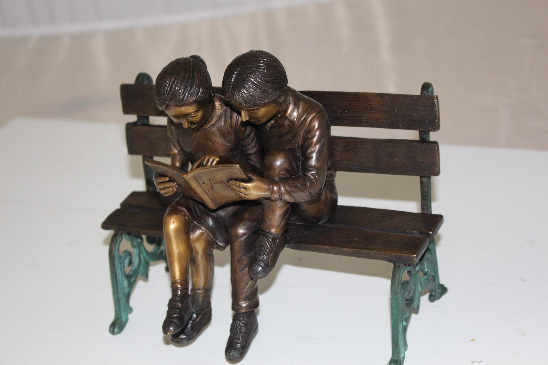 Two kids on bench reading a book - Bronze Statue -  Size: 9"L x 6"W x 8"H. 