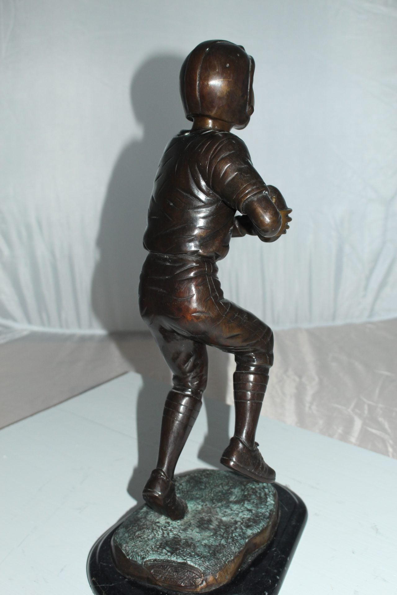Boy playing football Bronze Statue -  Size: 10"L x 8"W x 20"H. 
