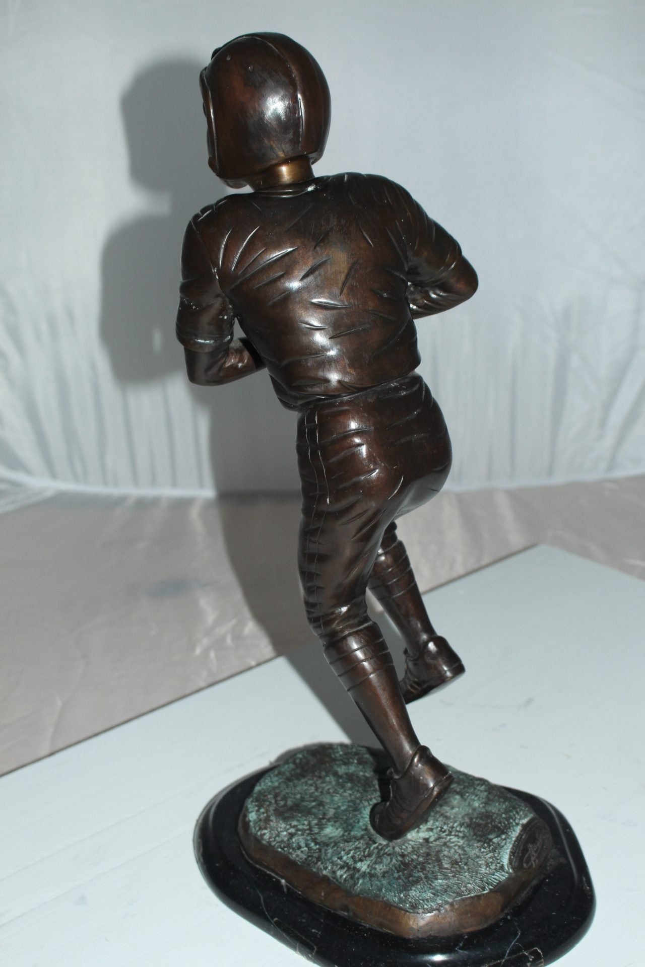 Boy playing football Bronze Statue -  Size: 10"L x 8"W x 20"H. 