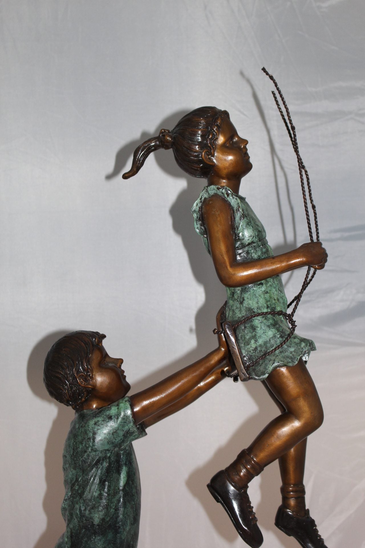 Children-on-swing-Bronze-Statue -  Size: 20"L x 9"W x 39"H. 