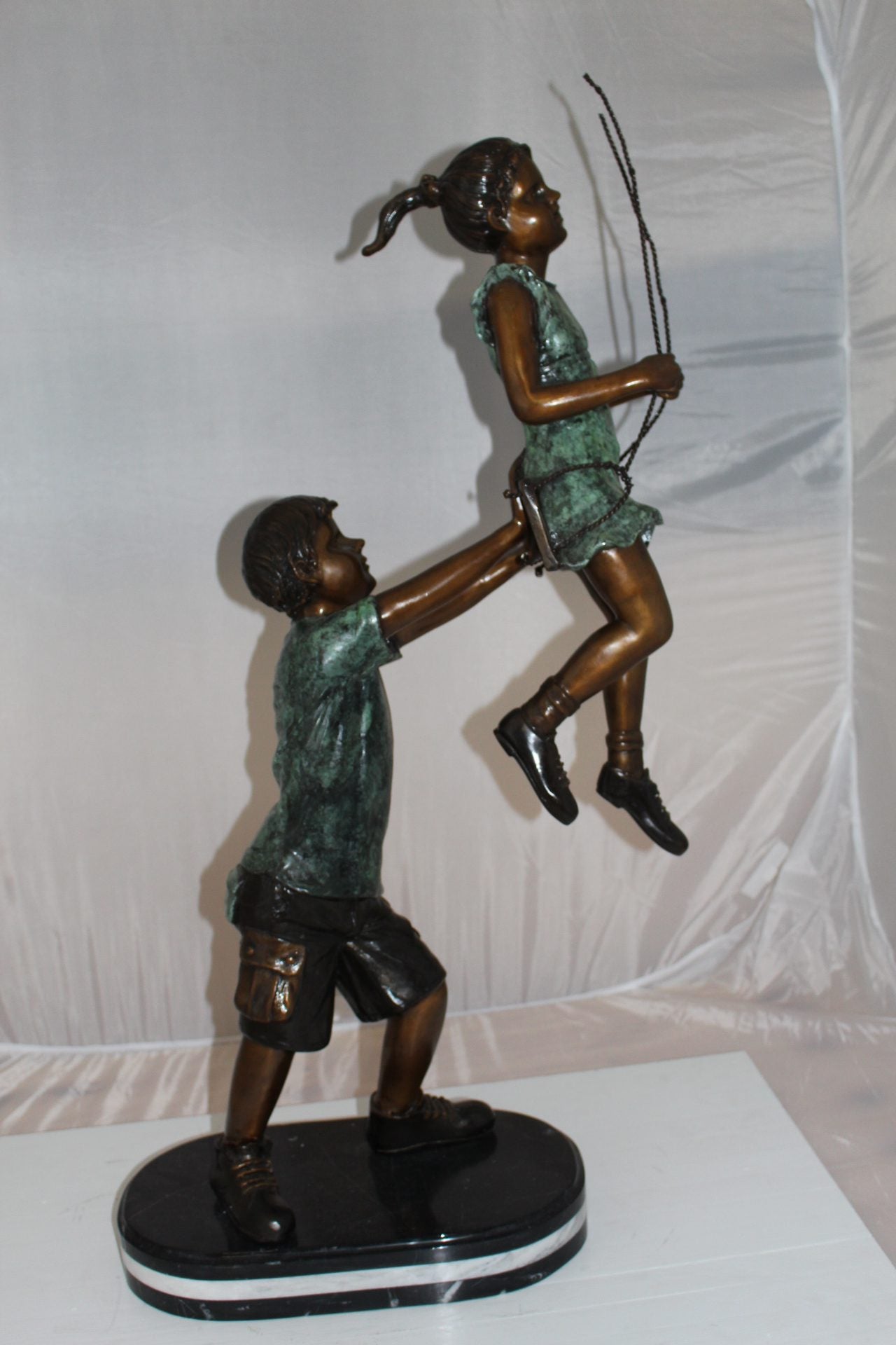 Children-on-swing-Bronze-Statue -  Size: 20"L x 9"W x 39"H. 