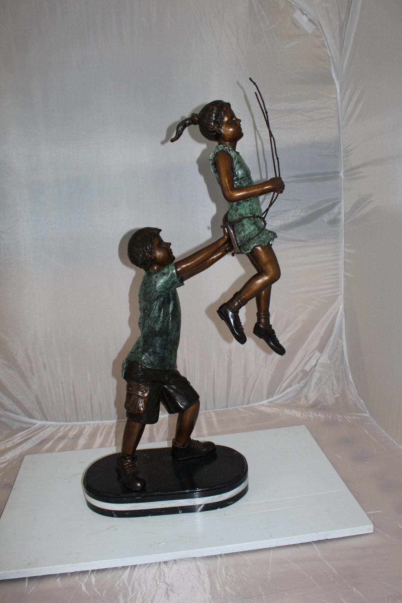 Children-on-swing-Bronze-Statue -  Size: 20"L x 9"W x 39"H. 