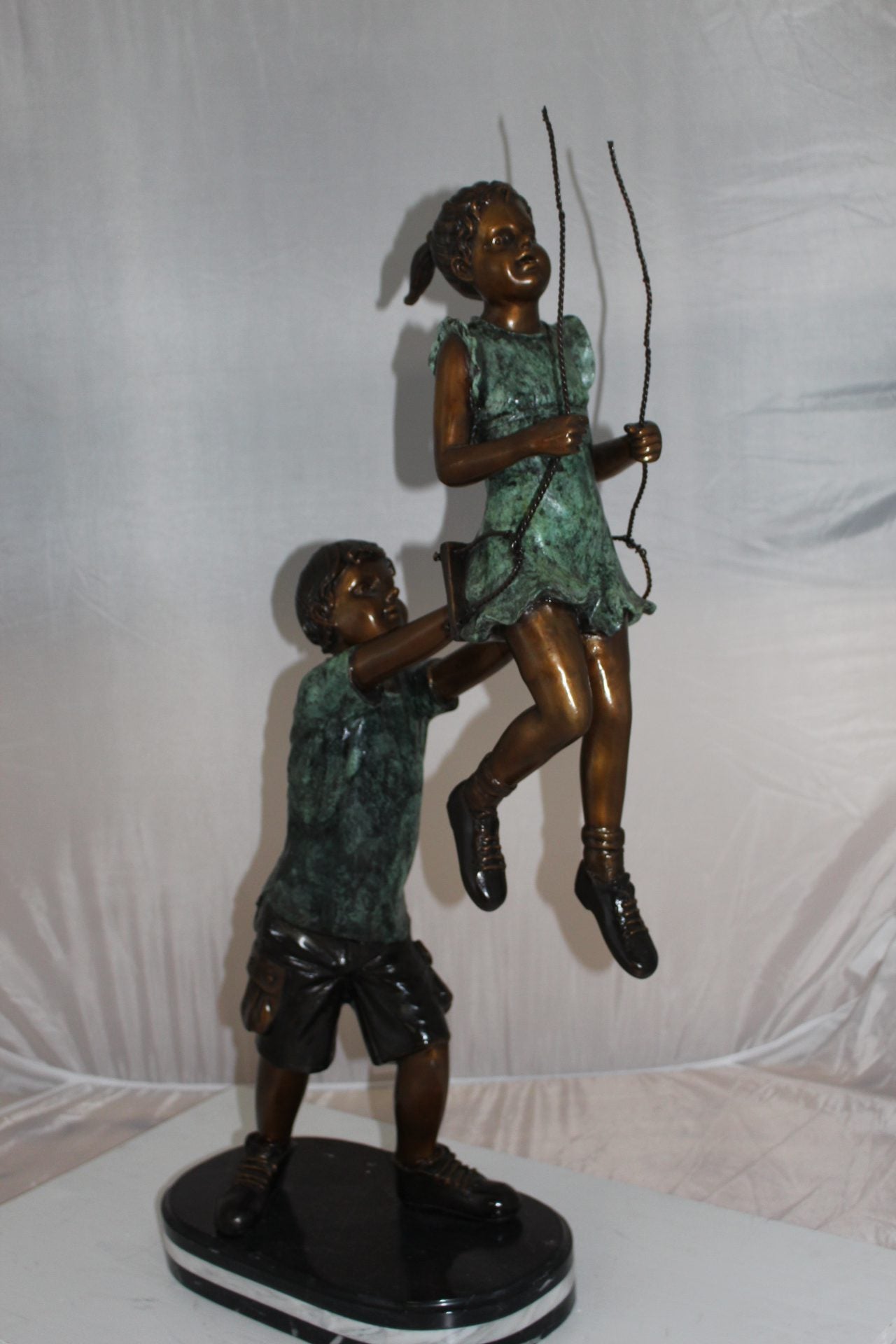 Children-on-swing-Bronze-Statue -  Size: 20"L x 9"W x 39"H. 