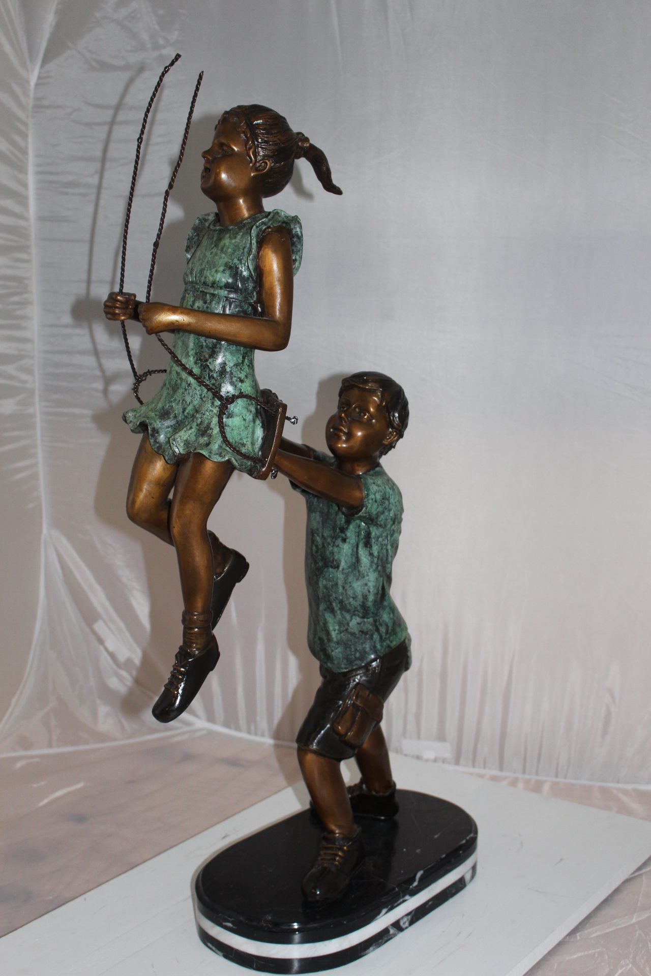 Children-on-swing-Bronze-Statue -  Size: 20"L x 9"W x 39"H. 