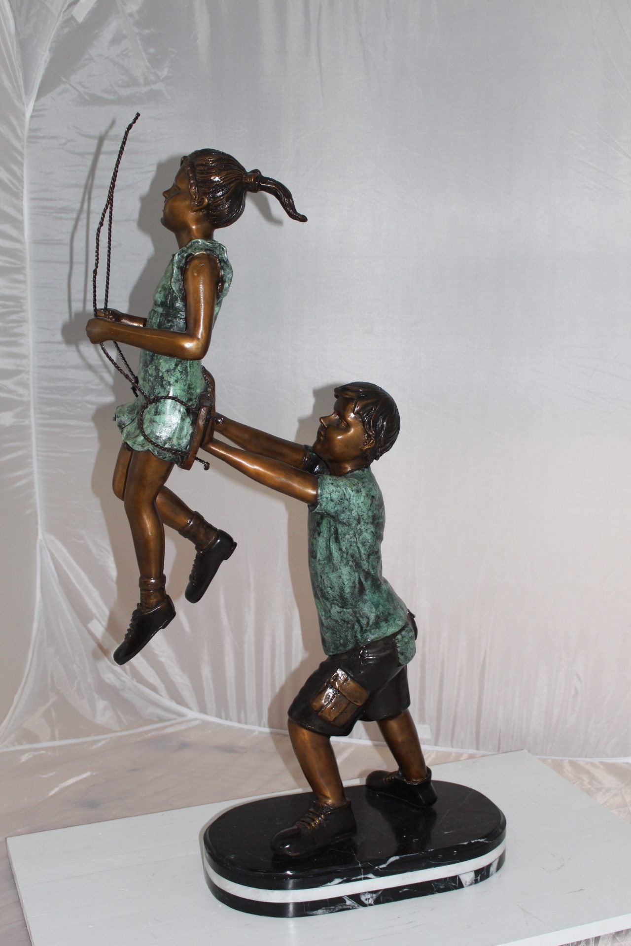 Children-on-swing-Bronze-Statue -  Size: 20"L x 9"W x 39"H. 