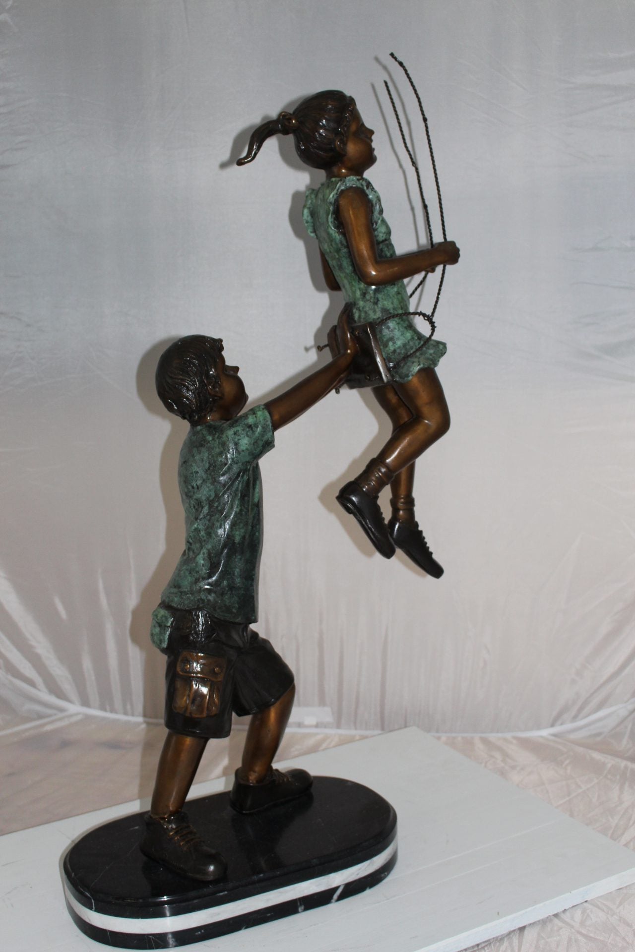 Children-on-swing-Bronze-Statue -  Size: 20"L x 9"W x 39"H. 
