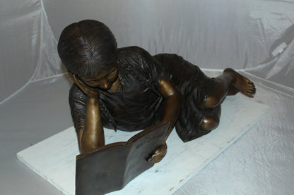 Girl laying reading a book Bronze Statue -  Size: 36"L x 17"W x 18"H. 