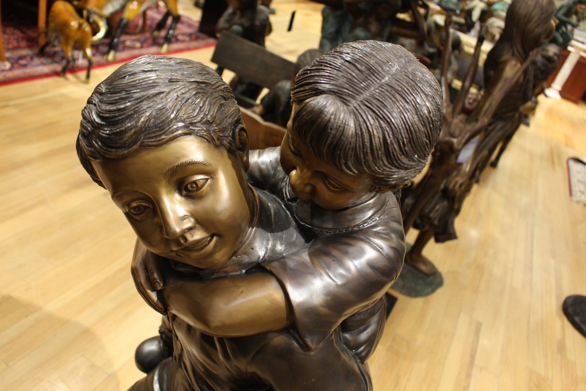 Boy Giving Girl Piggyback Ride Bronze Statue -  Size: 23"L x 16"W x 46"H. 