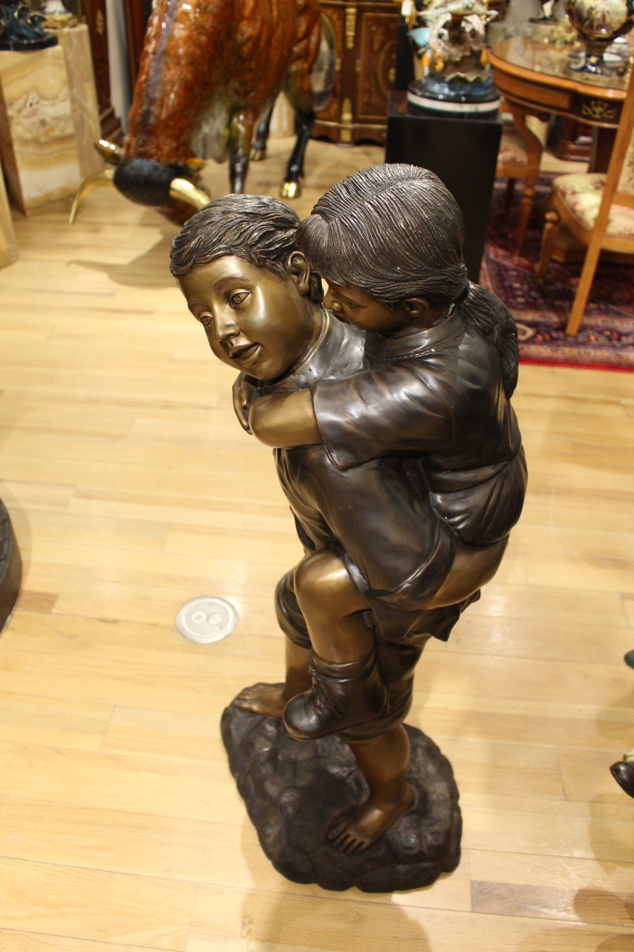 Boy Giving Girl Piggyback Ride Bronze Statue -  Size: 23"L x 16"W x 46"H. 