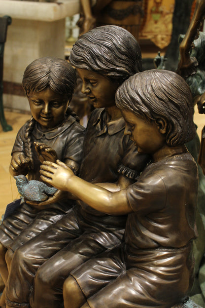 Three Children On Log Holding Bird Bronze Statue -  Size: 55"L x 18"W x 38"H. 