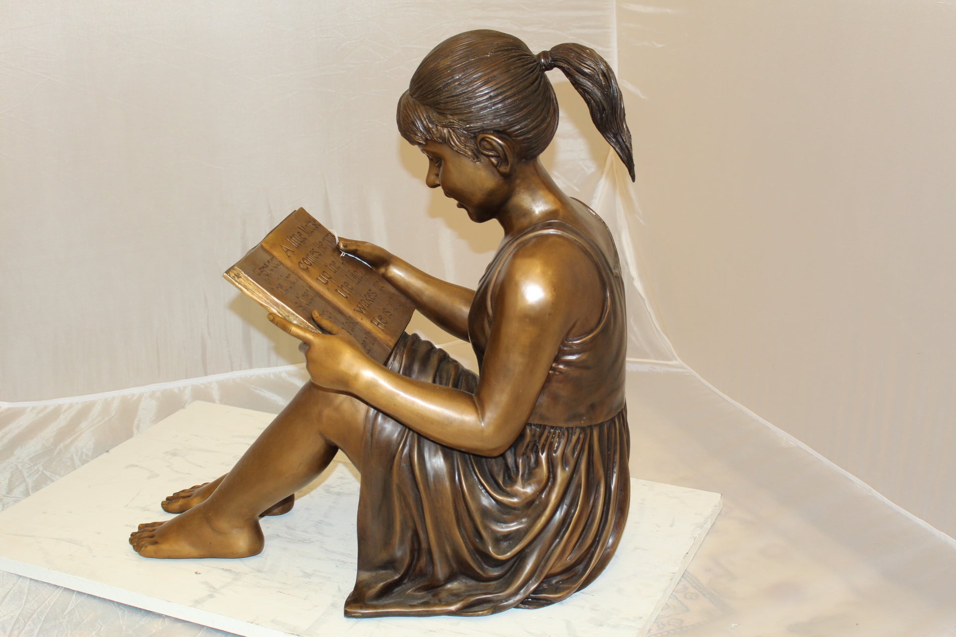 Girl Sitting and Reading a Book Bronze Statue -  Size: 23"L x 15"W x 24"H. 