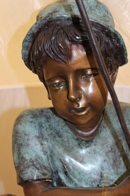 Boy Sitting on a Tree and Fishing Bronze Statue -  Size: 36"L x 21"W x 37"H. 