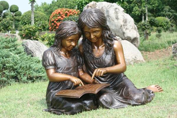 Two Girls Reading a Book Bronze Statue -  Size: 33"L x 21"W x 23"H.