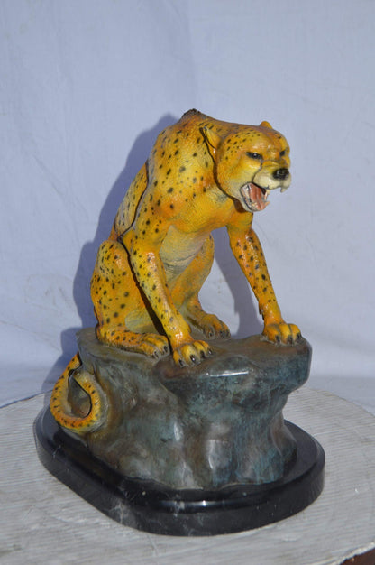 Cheetah sitting on a rock growling bronze statue - Size: 18"L x 12"W x 18"H.