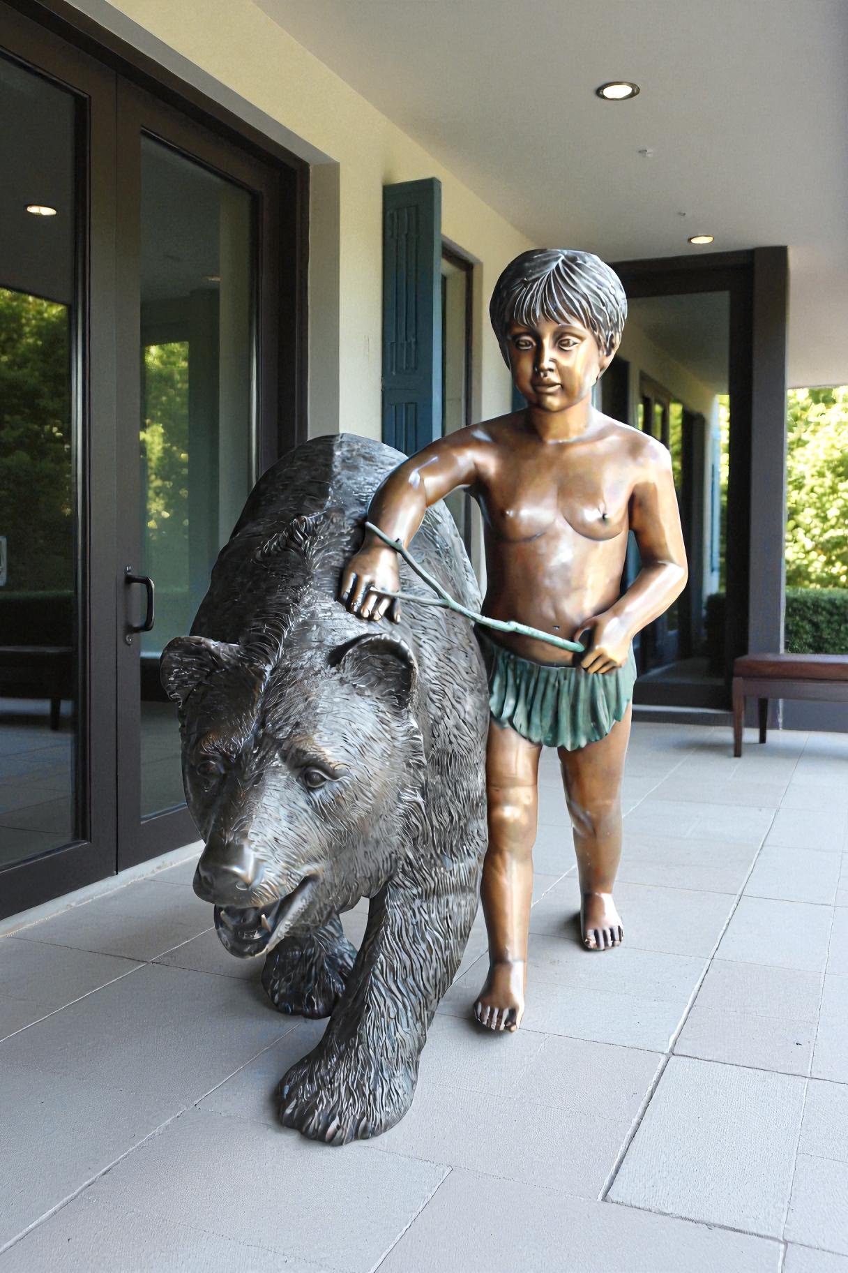 A bear with a boy bronze statue -  Size: 39"L x 24"W x 32"H.