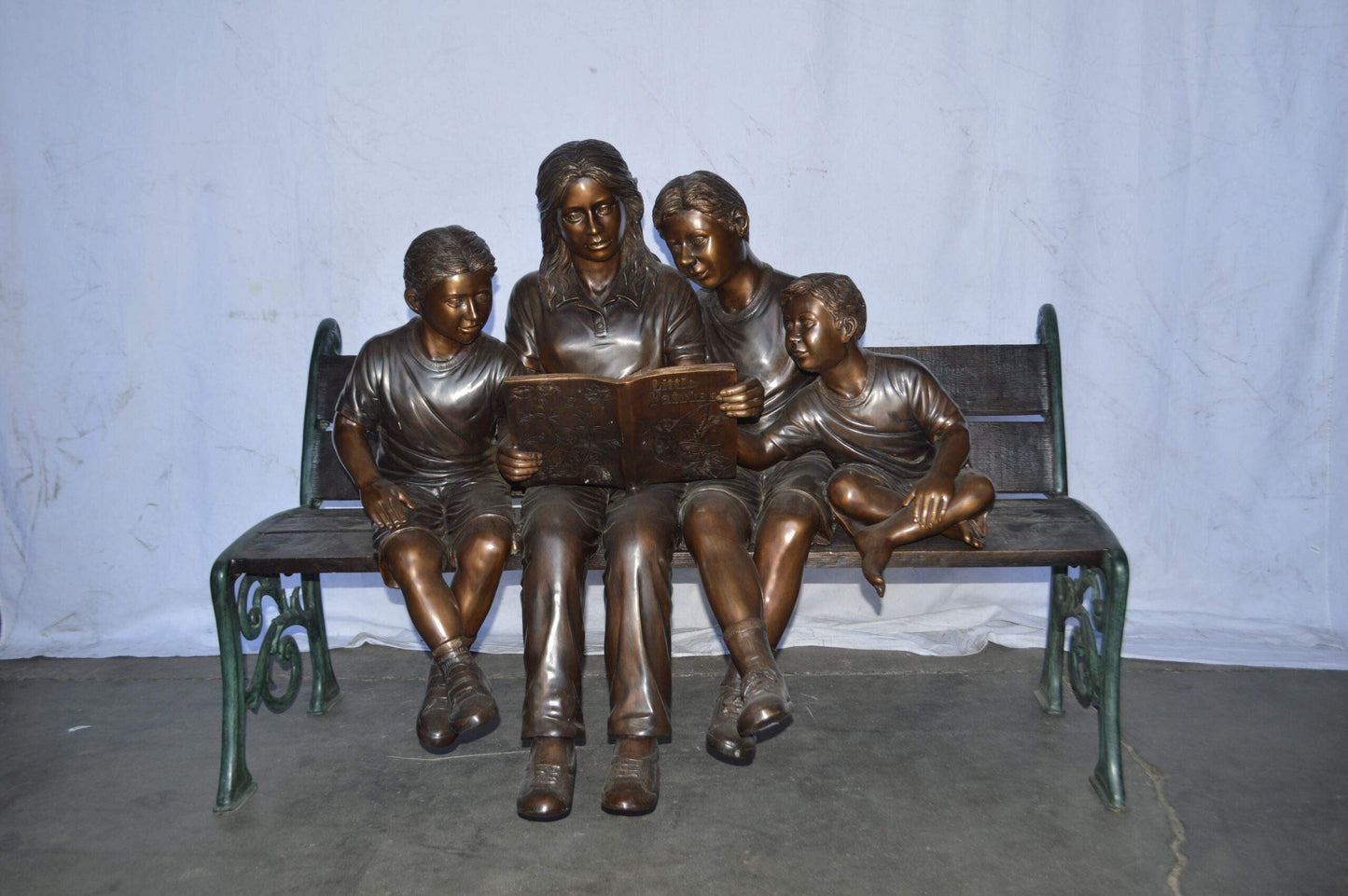Mom and boys reading stories on bench bronze statue - Size: 53"L x 33"W x 39"H.