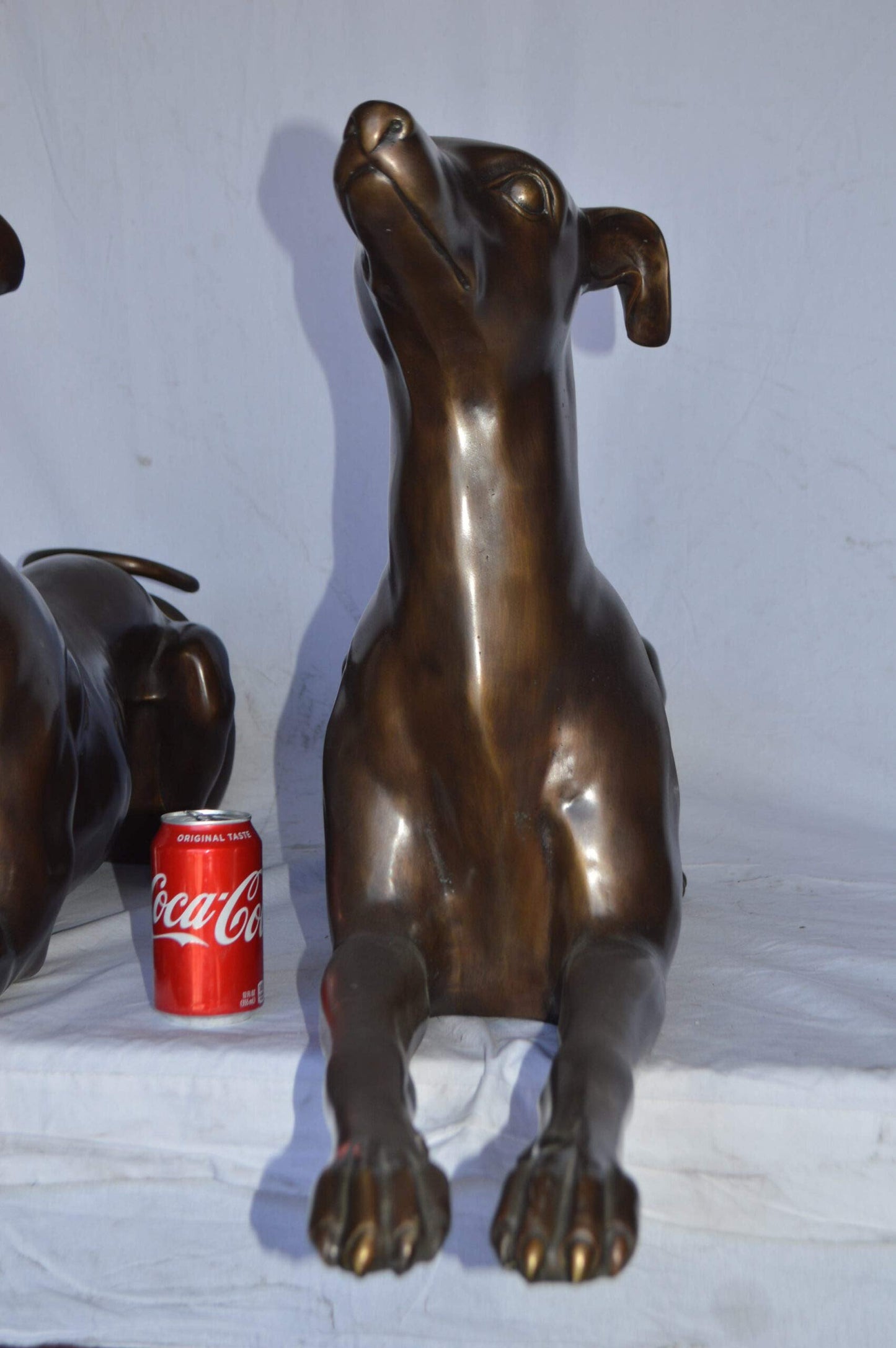 Pair of Greyhound dogs laying down Bronze Statues - Size: 50"L x 11"W x 20"H.