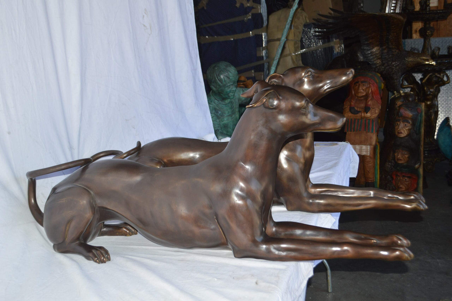 Pair of Greyhound dogs laying down Bronze Statues - Size: 50"L x 11"W x 20"H.
