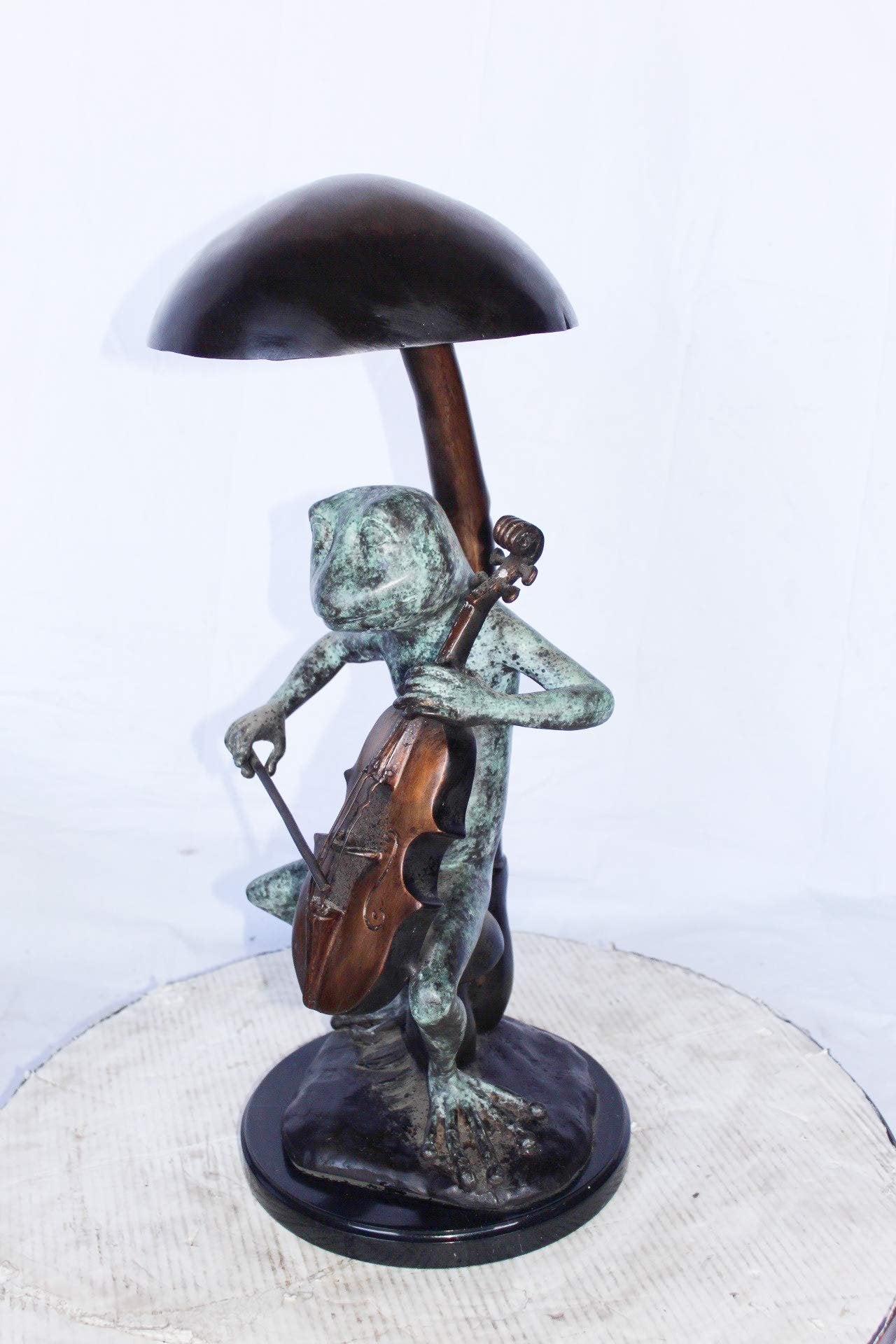 Frog playing cello under mushroom bronze statue -  Size: 10"L x 10"W x 24"H.