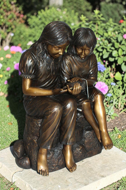 Two kids holding a bird Bronze Statue -  Size: 18"L x 26"W x 34"H.