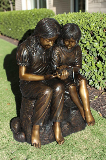Two kids holding a bird Bronze Statue -  Size: 18"L x 26"W x 34"H.