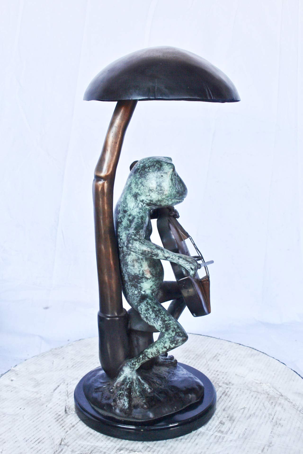 Frog playing cello under mushroom bronze statue -  Size: 10"L x 10"W x 24"H.
