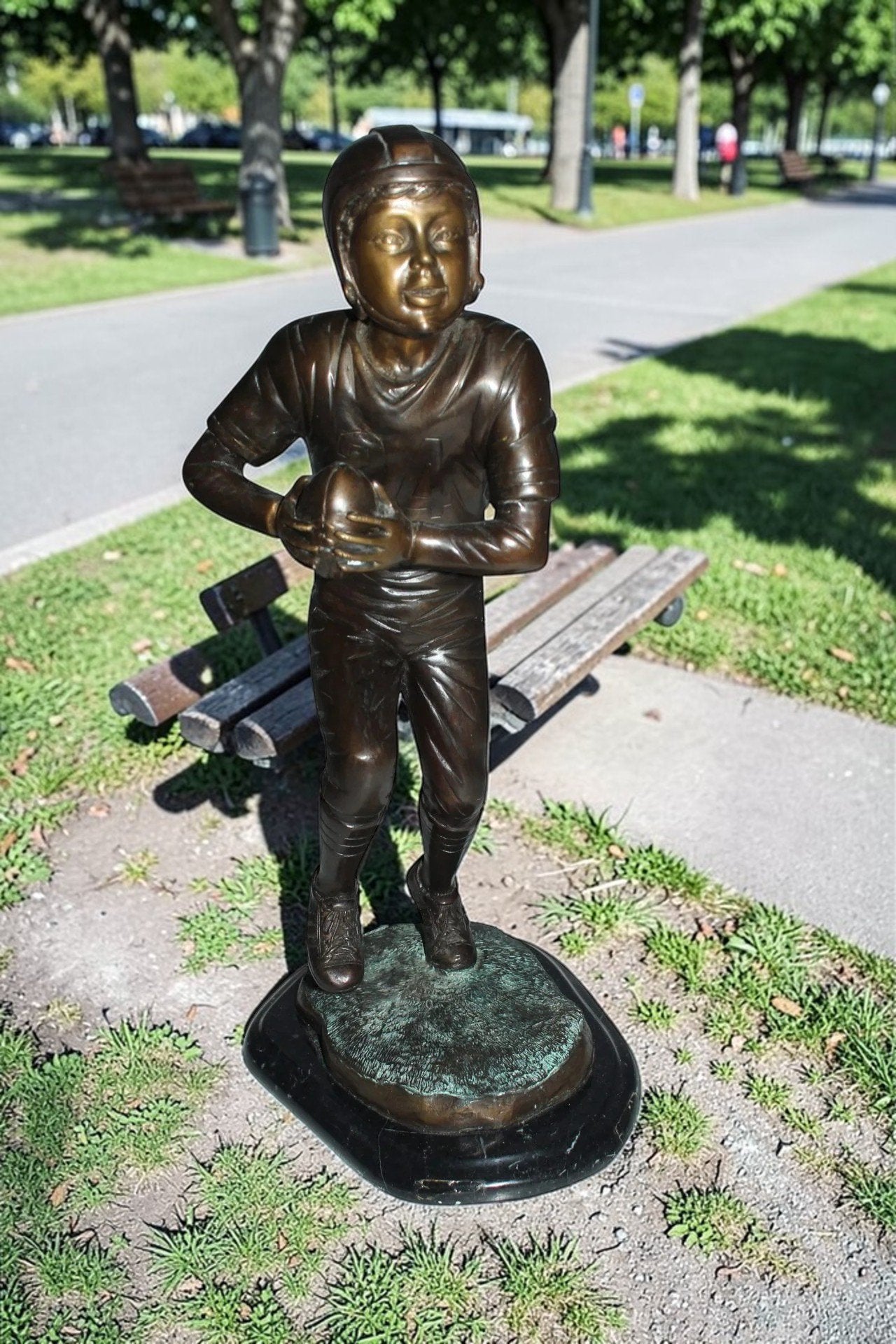 Boy playing football Bronze Statue -  Size: 10"L x 8"W x 20"H.