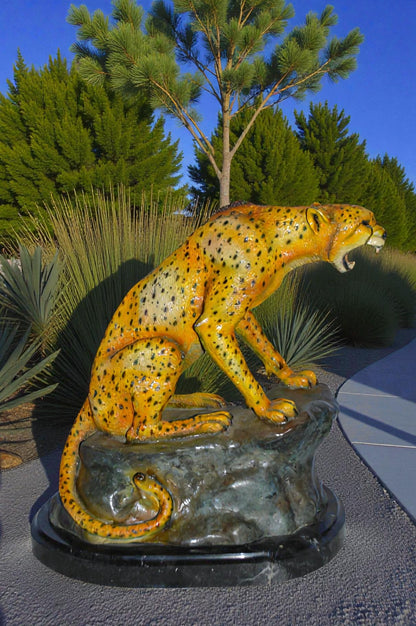 Cheetah sitting on a rock growling bronze statue - Size: 18"L x 12"W x 18"H.