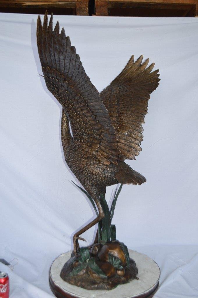 Crane standing on a stone bronze statue -  Size: 28"L x 32"W x 49"H.