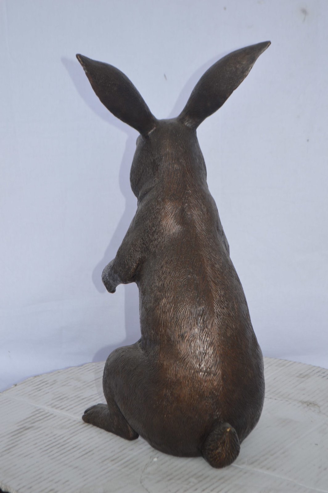 Rabbit looking down bronze statue - Size: 10"L x 12"W x 20"H.