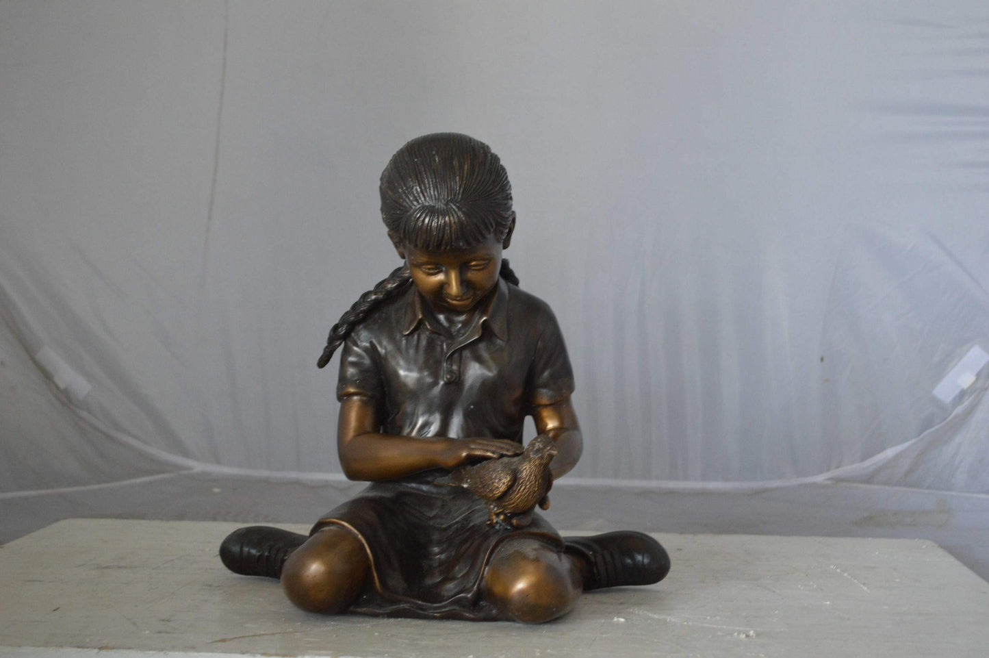 Young seated girl with bird bronze statue - Size: 12"L x 9"W x 14"H.