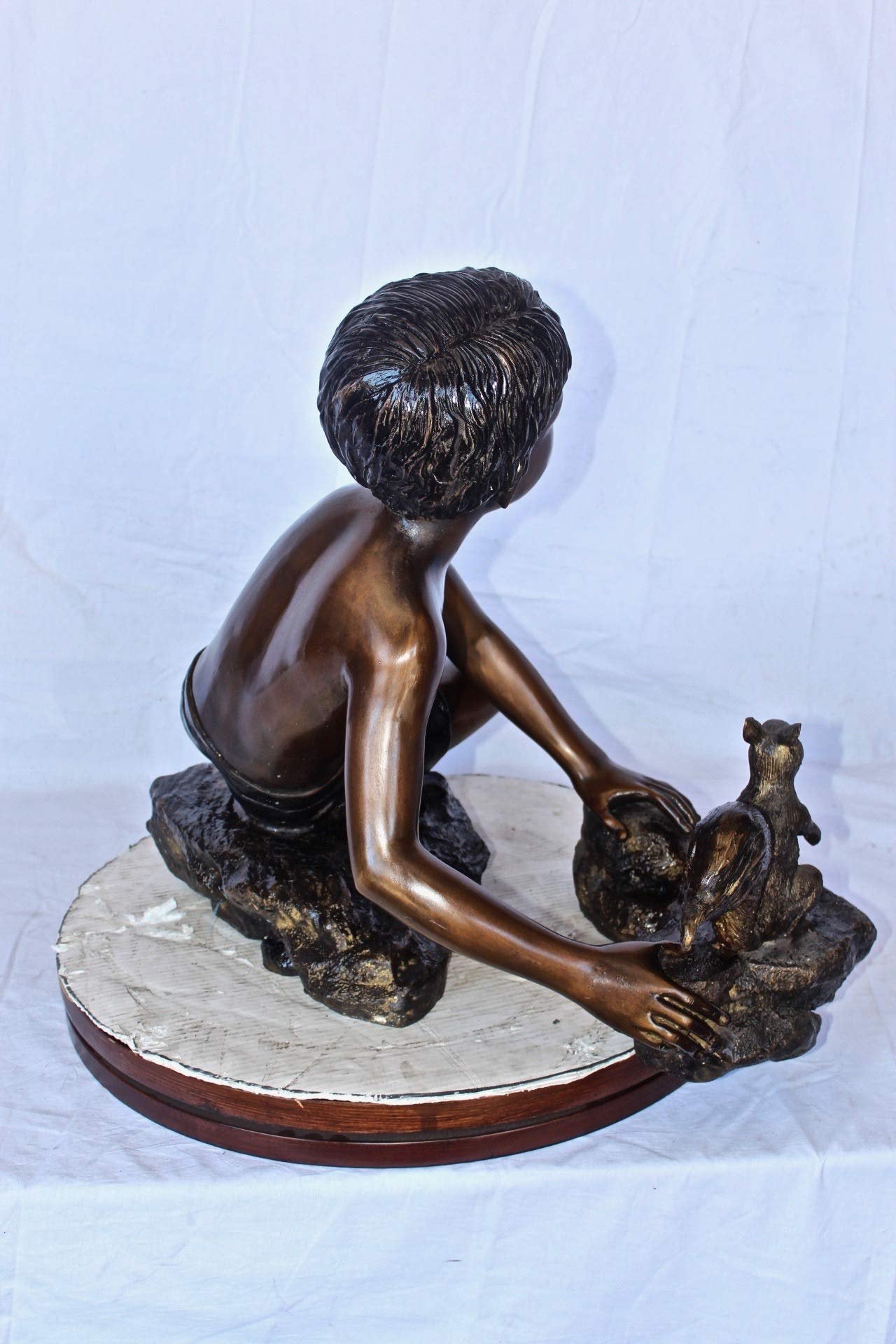 Adventurous boy with squirrel bronze statue -  Size: 36"L x 18"W x 22"H.