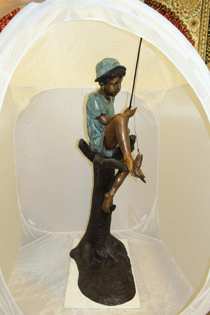 Boy Sitting on a Tree and Fishing Bronze Statue -  Size: 34"L x 28"W x 64"H.