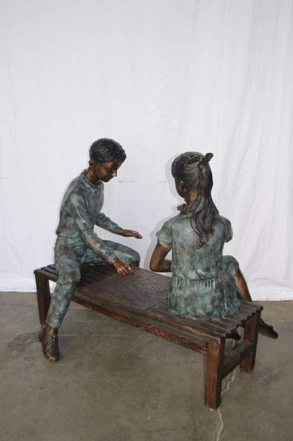 Young Couple Reviewing a World Map Bronze Statue -  Size: 32"L x 47"W x 42"H.