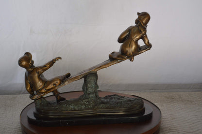 Boys Playing Seesaw on a Marble Base Bronze Statue -  Size: 22"L x 8"W x 17"H.