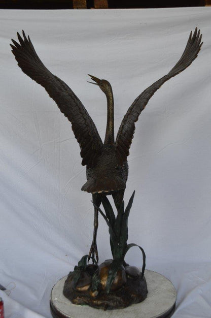 Crane standing on a stone bronze statue -  Size: 28"L x 32"W x 49"H.