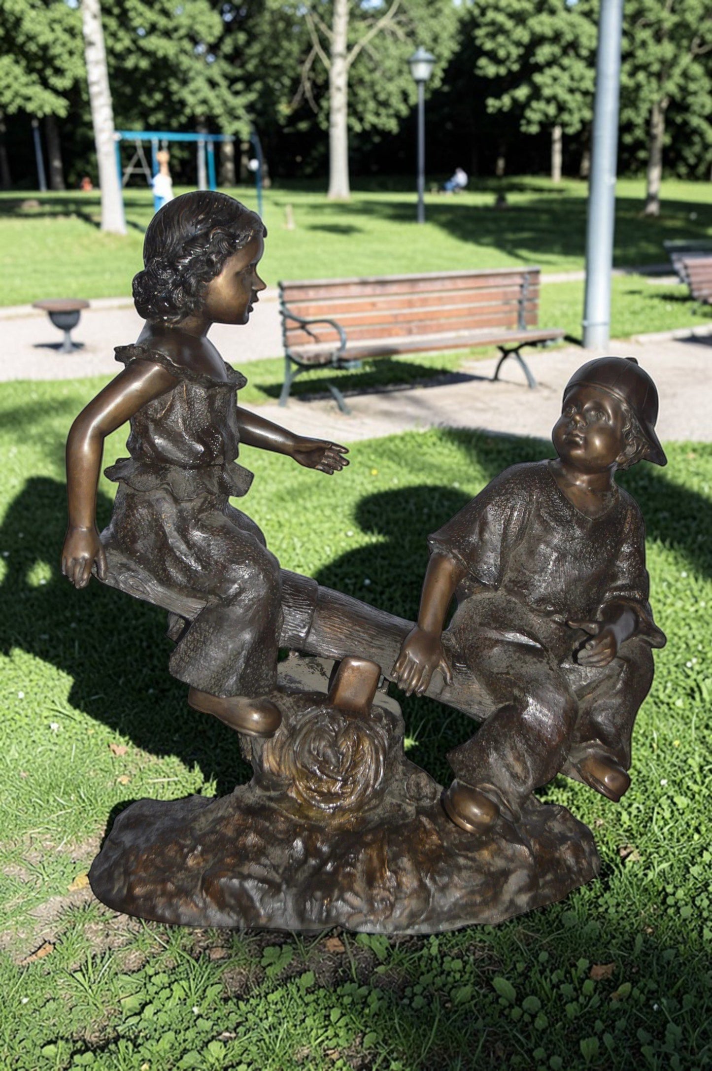 A Boy and a Girl Playing Seesaw Bronze Statue - Size: 17"L x 33"W x 36"H.